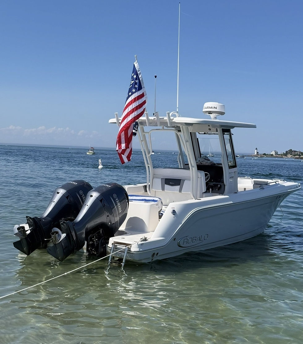 Photo of the Robalo boat at anchor in shallow clear water with an American flag