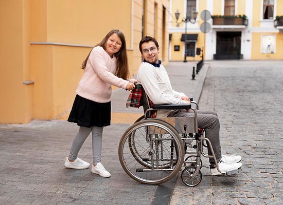 girl-helping-disabled-man-traveling-city.jpg