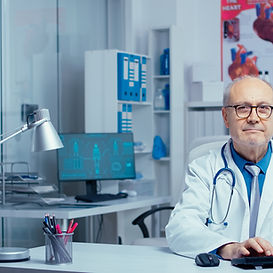 doctor-looking-camera-after-typing-computer-modern-private-hospital-clinic-working-consult