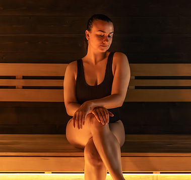 woman-seated-sauna-bench-calm-cozy-mood-warm-light-relax-steamroom.jpg