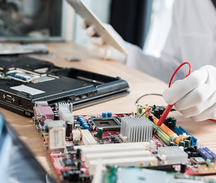 male-technician-examining-mother-board-with-digital-multimeter.jpg