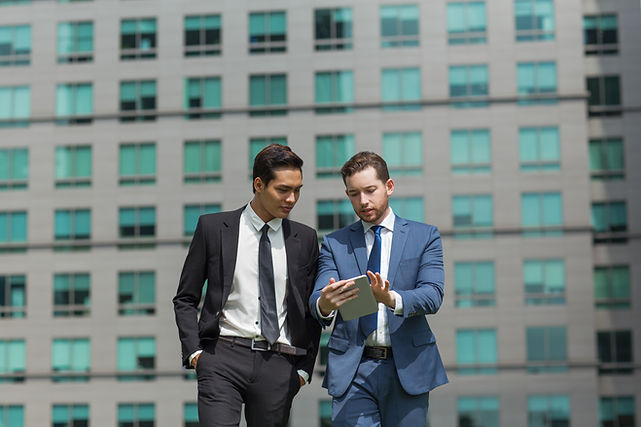 two-content-business-men-using-tablet-walking.jpg