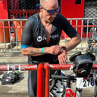 Triatleta Carlos Acuña mirando su reloj en una transición.