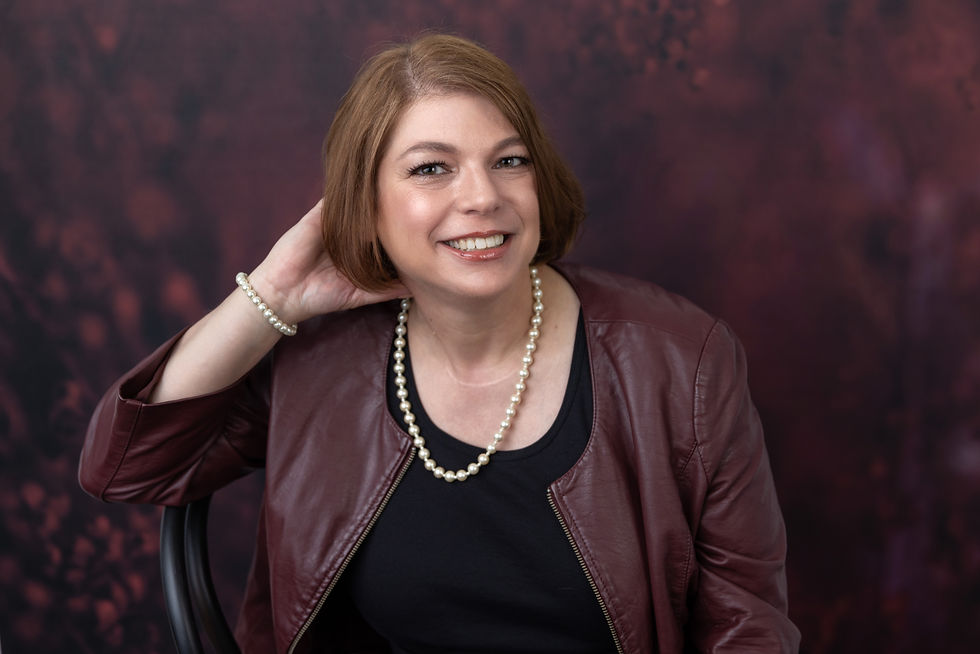 Rachel in burgundy jacket with pearl necklace and bracelet
