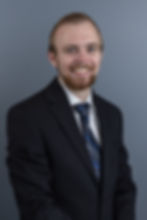 Man in a black suit jacket in his headshot picture