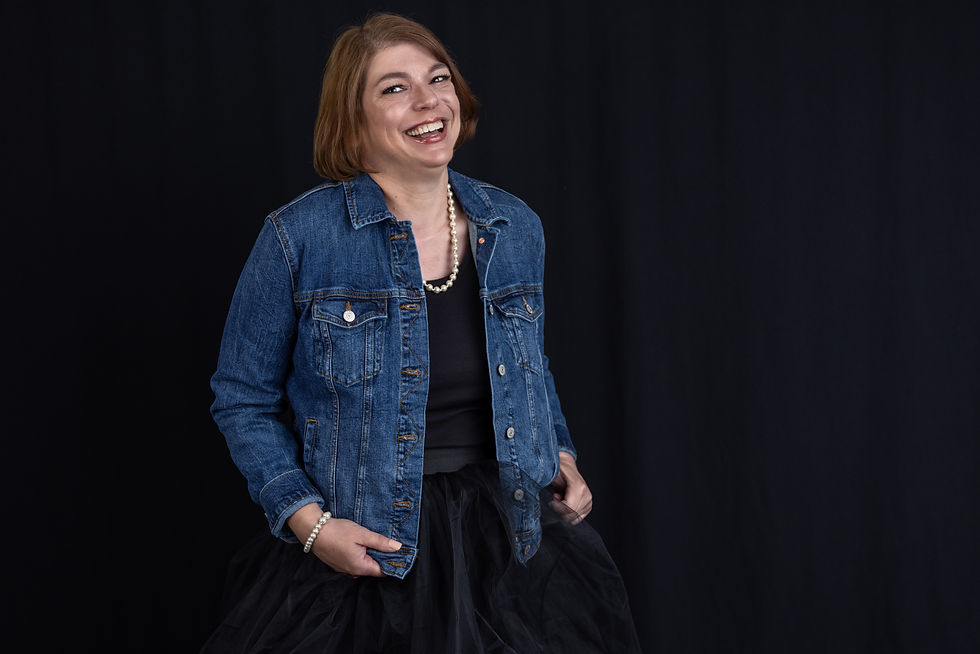 Beauty Portrait over 40 woman in denim jacket and tulle skirt with pearls laughing