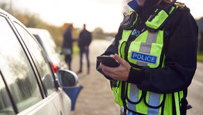 Police officer stood by a car