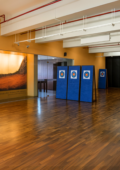 Modern indoor archery range with hardwood floors and target stations designed for professional training and recreation.