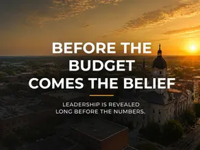 Before the Budget Comes the Belief cover featuring a municipal downtown at sunset, exploring leadership, stewardship, and municipal budgeting.
