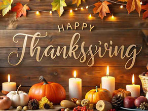 A Thanksgiving-themed display featuring pumpkins, autumn leaves, candles, and seasonal decorations arranged in front of a rustic wooden backdrop with the words “Happy Thanksgiving” in large script. The warm lighting and fall colors create a festive holiday atmosphere for the Hazel Crest Thanksgiving Giveaway blog article.