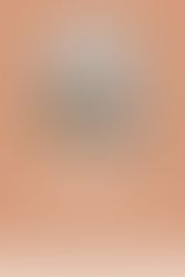 Woman sitting on the floor in a calm living room space with an incense holder in the foreground, representing mindfulness and a holistic therapy intensive.