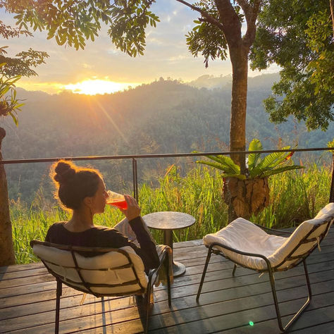 A woman relaxing at a wellness retreat, savouring the perfect sunset