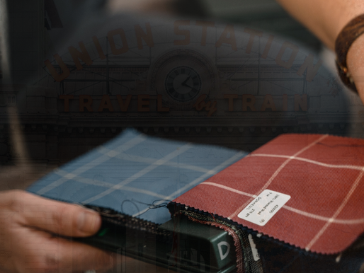 A selection of patterned fabric swatches is held against a backdrop of the iconic Union Station sign, blending craftsmanship with travel nostalgia.