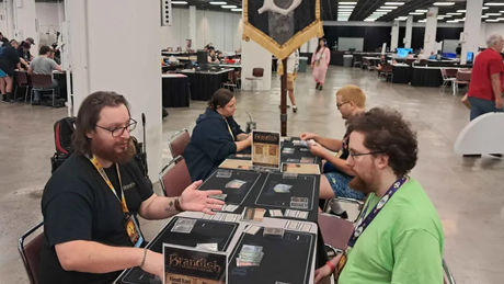 Demo table with players under Brandish's battle standard.