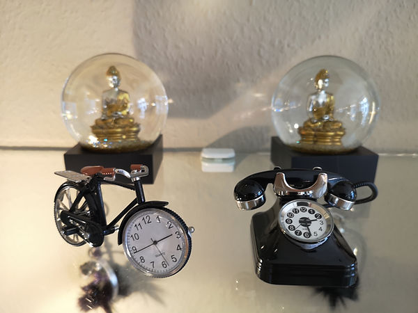 tischuhren-fahrrad-telefon mit uhr, schneekugel mit buddah bei herda fahion in kempen
