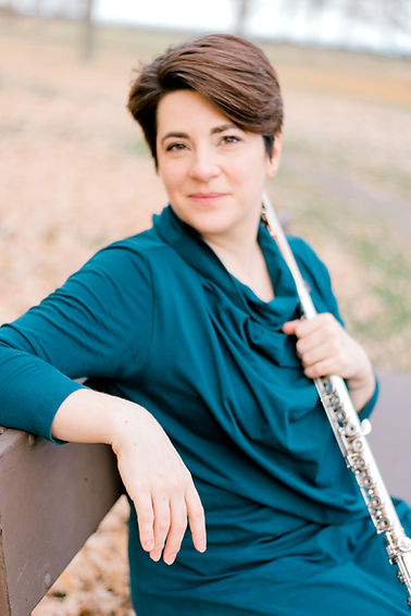 Shanna on a bench with flute smiling