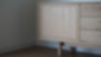 A close-up of a modern solid oak cabinet door showing a clean, dark reveal line between the frame and the flat panel.
