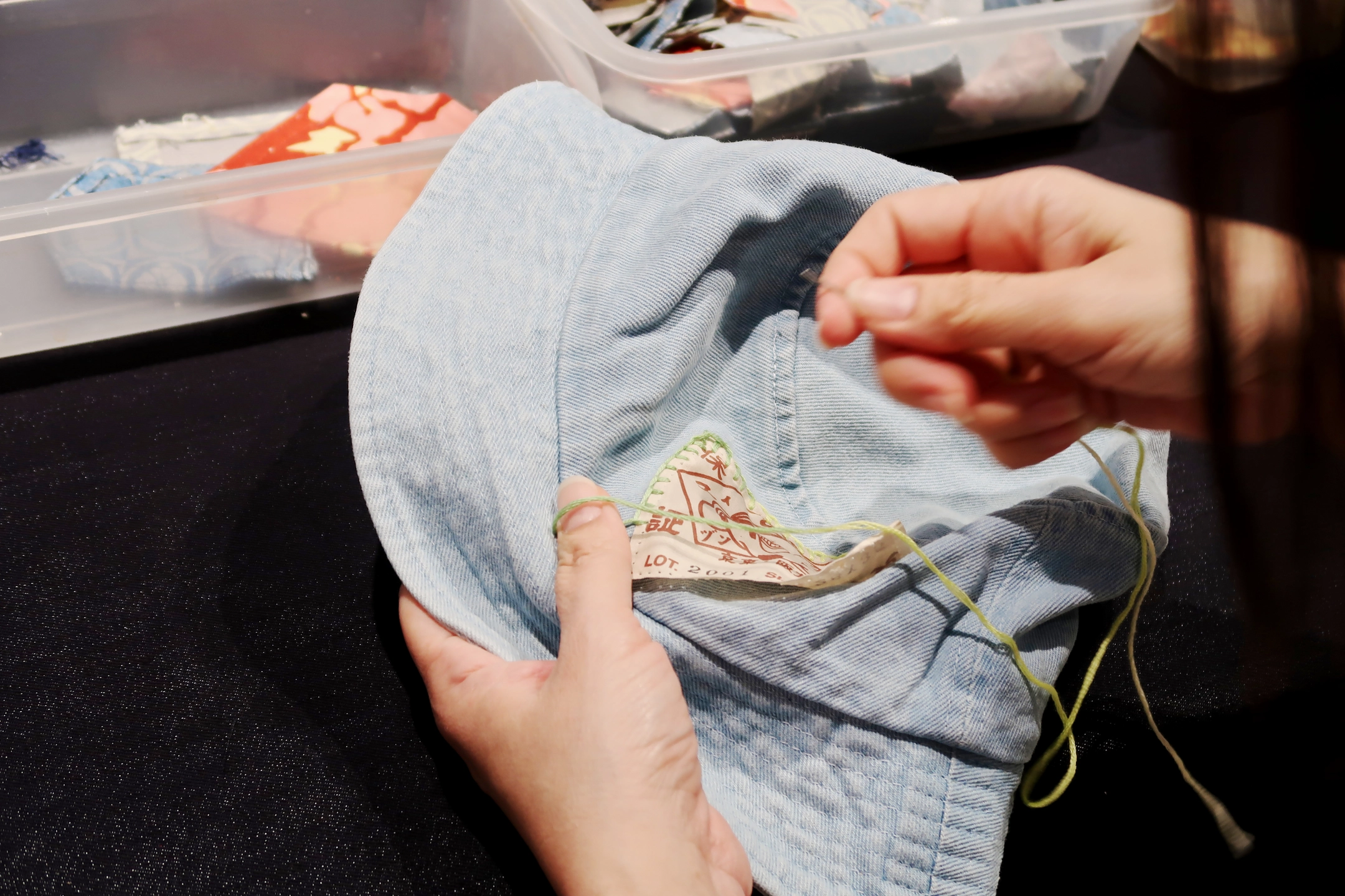 visitors customising evisu denim crossbody bags with patchwork and embroidery at evisu bangkok flagship anniversary event by GIGIPAYNE