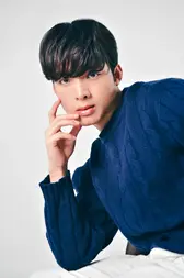Man in blue sweater posing at photo studio