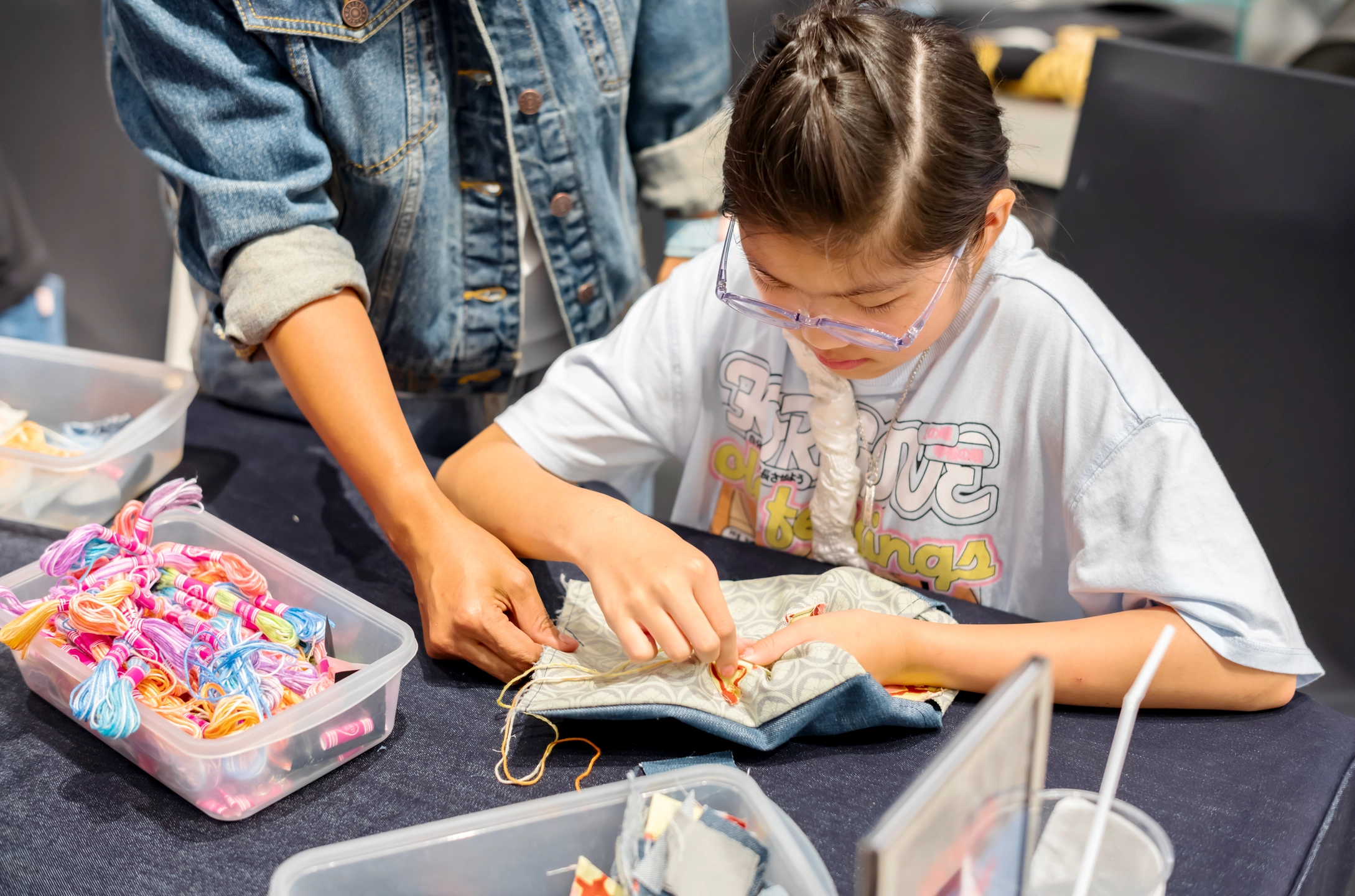 visitors customising evisu denim crossbody bags with patchwork and embroidery at evisu bangkok flagship anniversary event by GIGIPAYNE