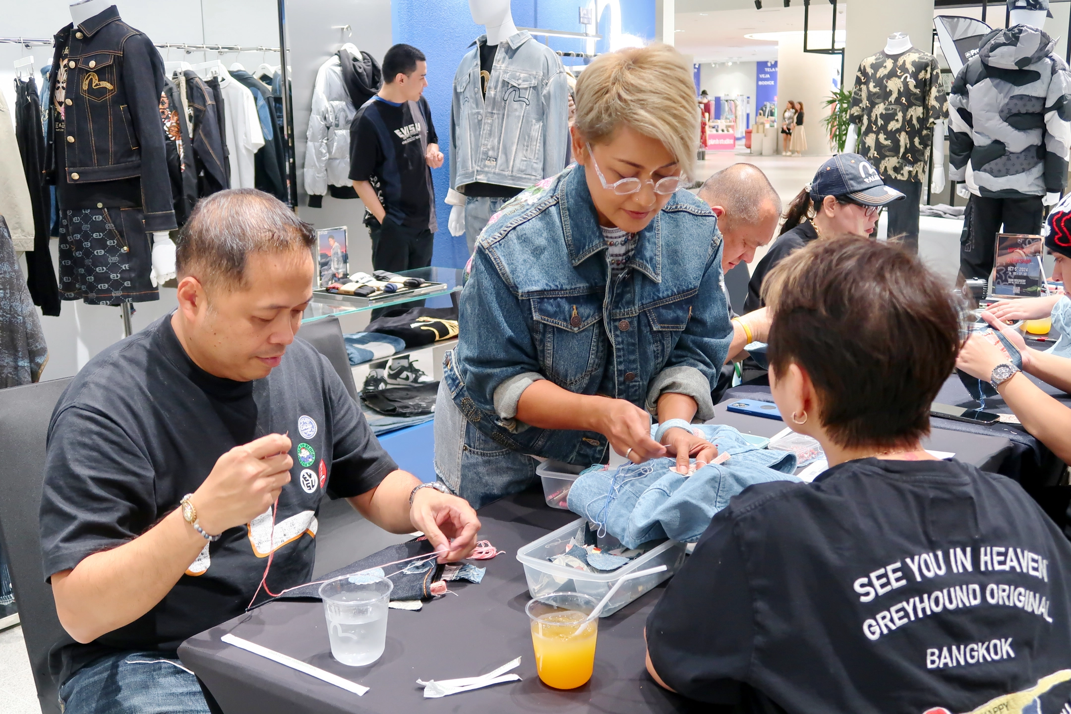visitors customising evisu denim crossbody bags with patchwork and embroidery at evisu bangkok flagship anniversary event by GIGIPAYNE
