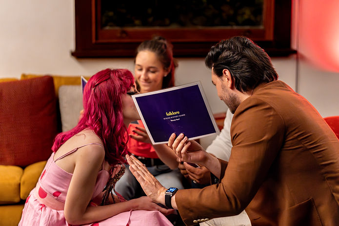 Three players discuss theories hiding behind a reference sheet at the best murder mystery perth has to offer, a folklore murder mystery event