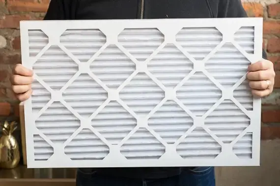 A person holding up a hvac filter