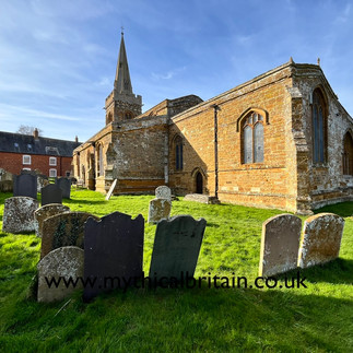 south east view of the church showing gravestones in the foreground and the main church body behind. A house is visible in the distance