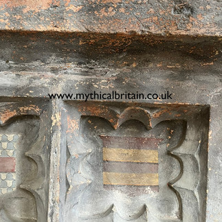 Close up of a decoration showing a painted shield on a tomb
