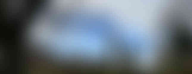 Fences, fields and low farm buildings in the foreground with two huge towers behind