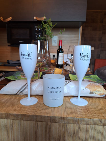 Coupes de bienvenue et bougie pour un séjour romantique et festif au gîte insolite Temps 1solite.