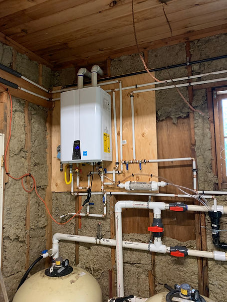 A photo of a furnace with pipes and cables inside a room.