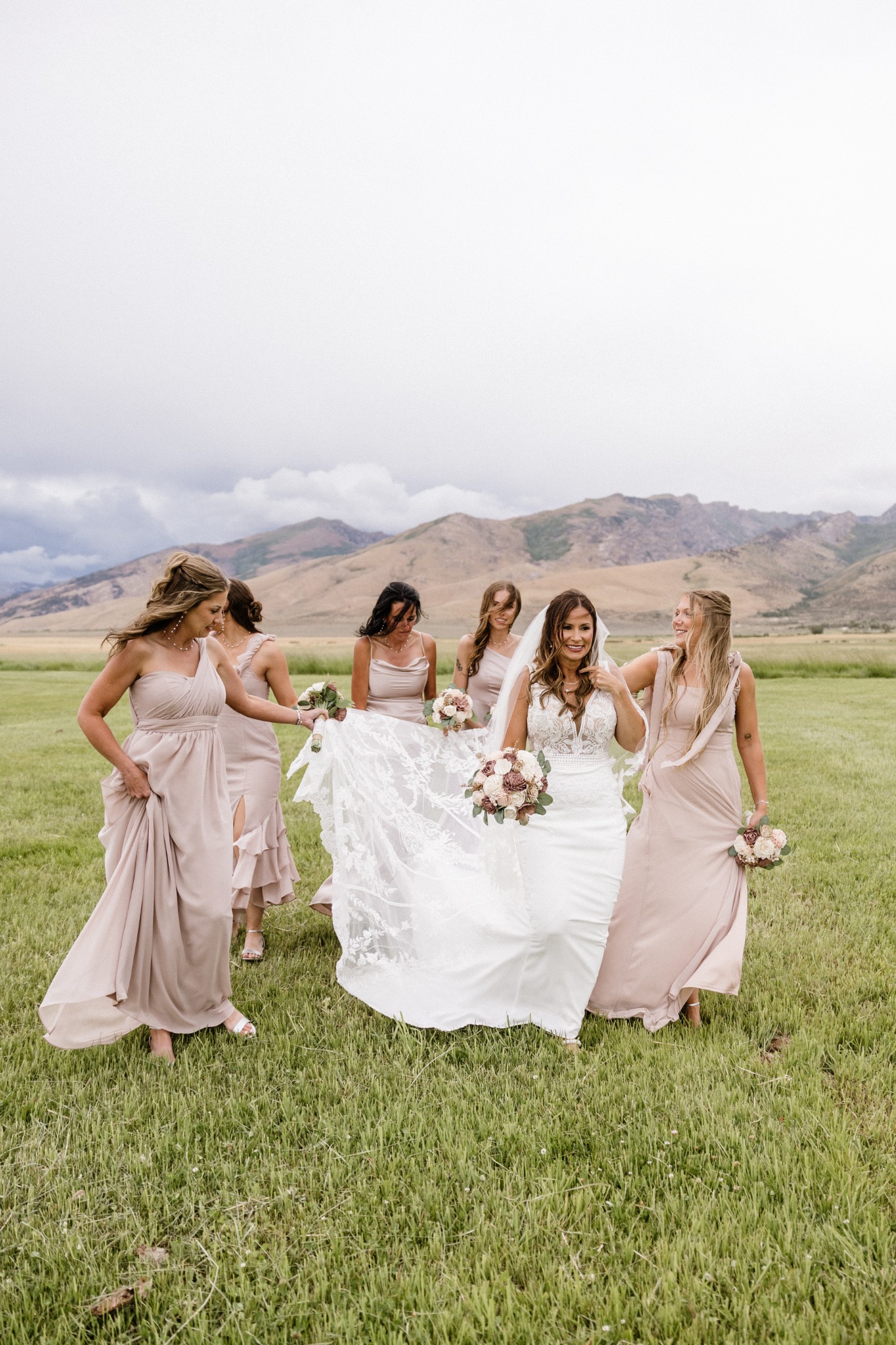 Amy and her bridesmaids walking together through a mountain meadow