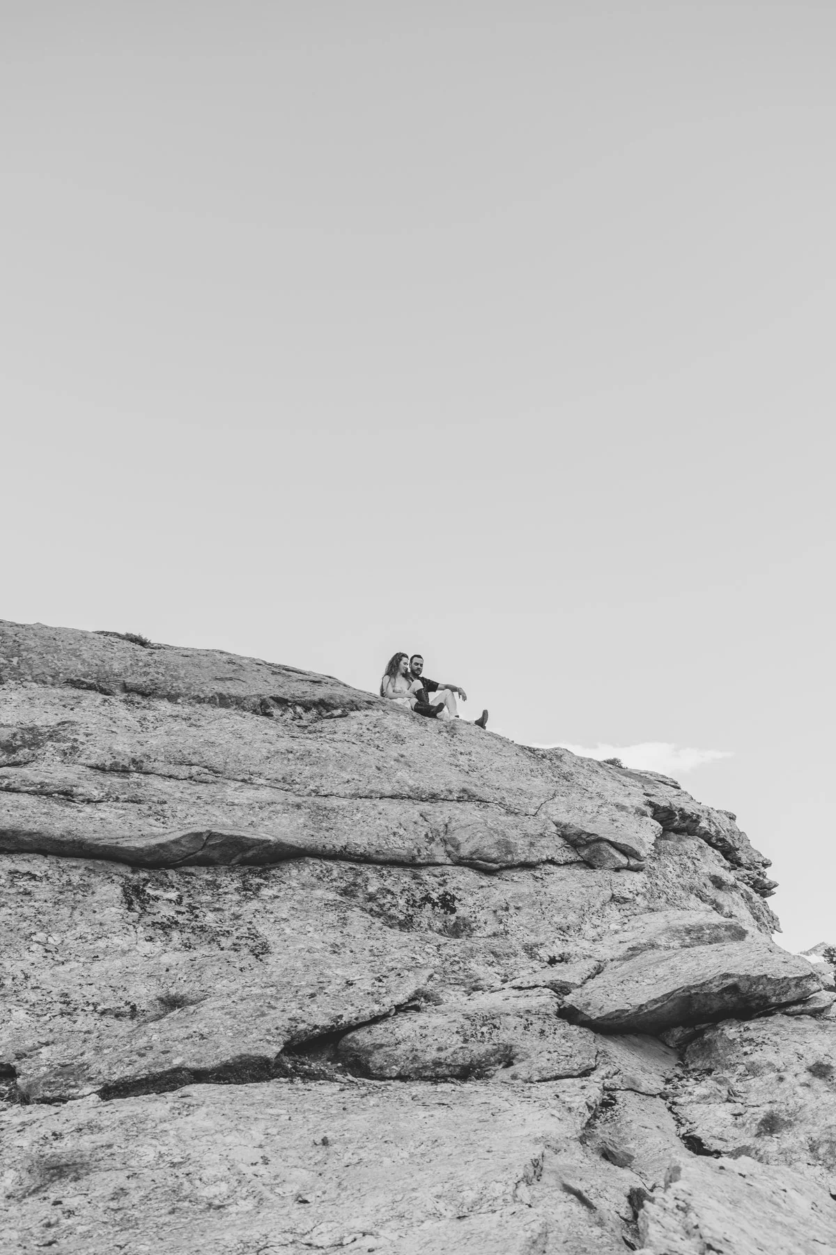 Couple standing together on a rocky ridge