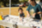 family playing at a water table at an event