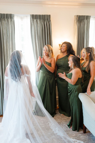 Bridesmaids reacting to seeing the bride in her wedding dress for the first time at Eolia Mansion bridal suite