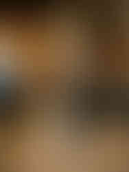 Bride and groom sharing their first dance while classical wedding musicians perform live in a candlelit barn reception setting