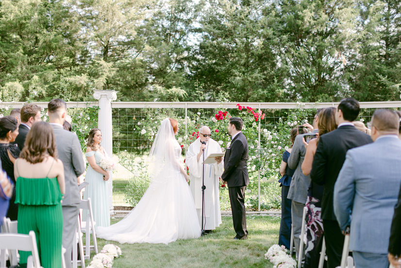 bride and groom taking their vows at Wadsworth Mansion wedding ceremony in rose garden