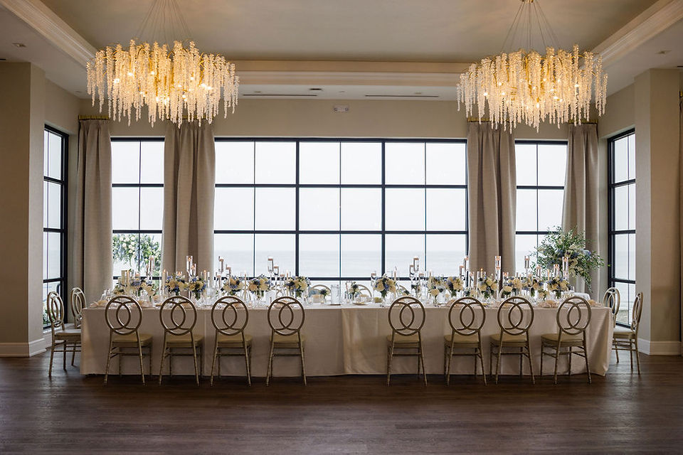Tyde at Walnut Beach Wedding reception table with white linens and chandeliers overhead