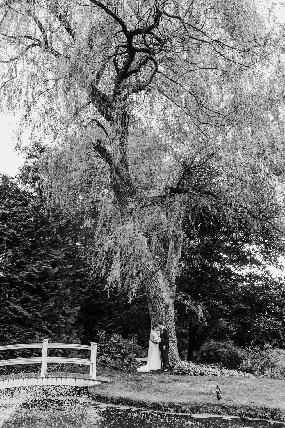 black and white photo of bride and groom walking at the woodwinds in branford