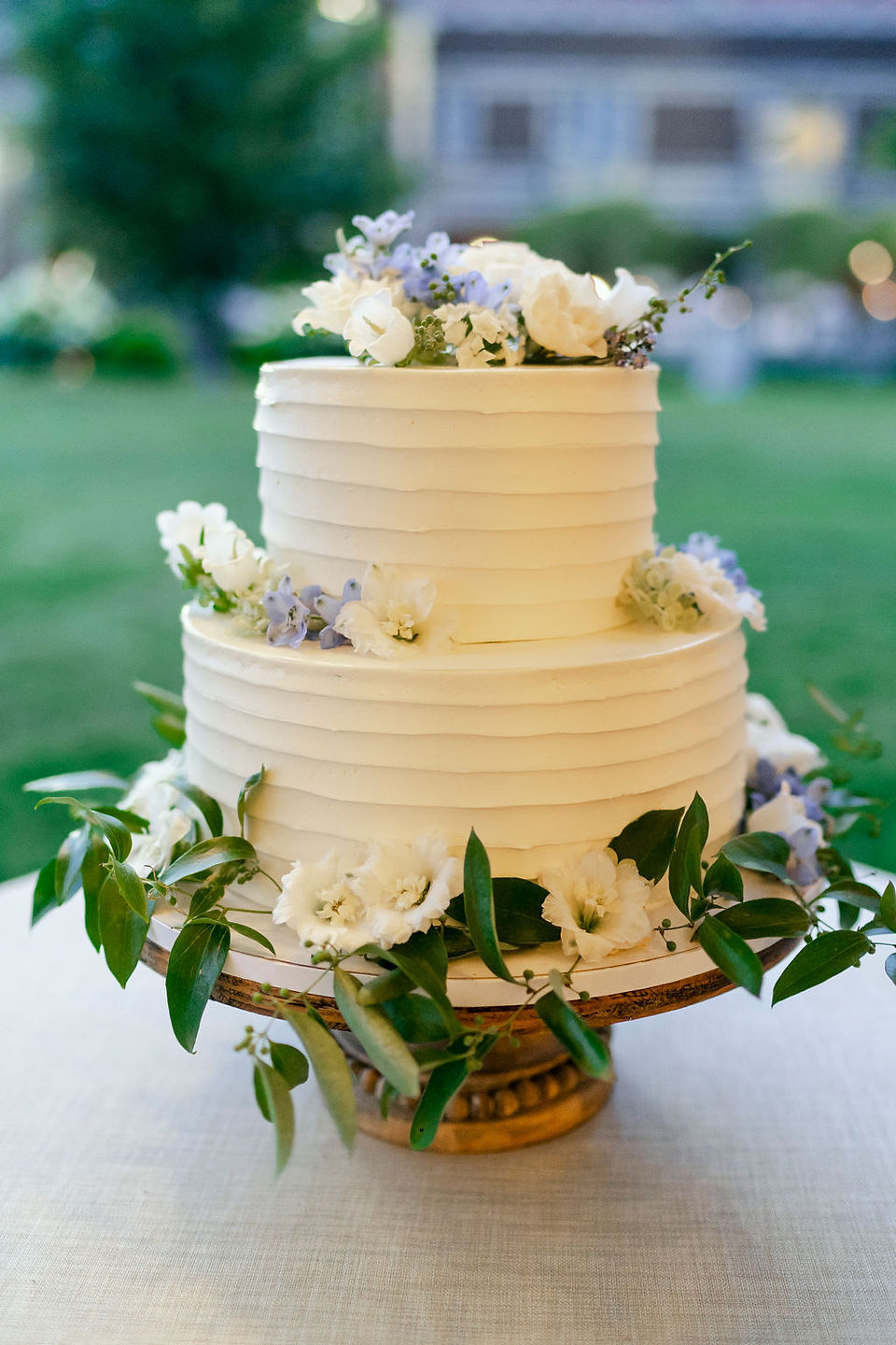White cake adorned with florals for wedding at Waveny House
