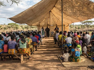 Pastors and church leaders gathered under a tent in rural Africa for Bible training and teaching led by Christian ministry leaders