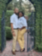 Anthony Rauls and Latonya Rauls standing together in a garden archway, representing their entrepreneurial journey and family legacy.