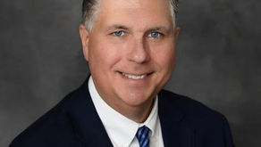 John Crawford government affairs principal Coleman Talley Strategies wearing dark suit blue striped tie professional headshot