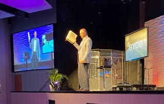 Daniel preaching at a church event, delivering a message on Holy Spirit renewal and leadership equipping.