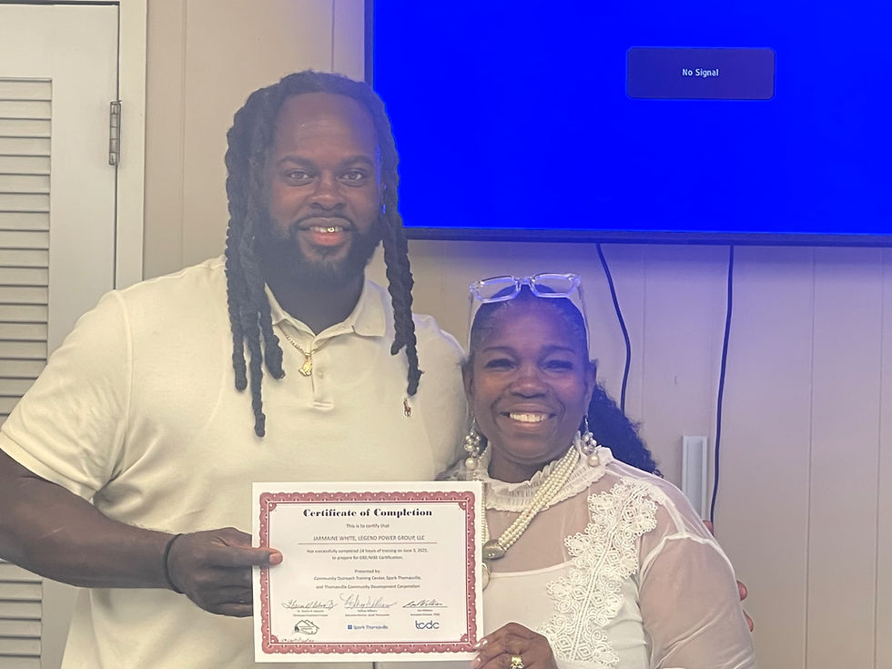 Jarmaine White smiling and holding a certificate next to Dr. Sharon Edwards during a business certification graduation event in Thomasville.