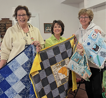 NJHealth's Margie Barham (center) accepts quits for patients from South Shore Stitchers Quilt Guild Comfort Care Co‑chairs, Sue Hanlon (left) of Somers Point and Diana Easterday (right) of Mays Landing
