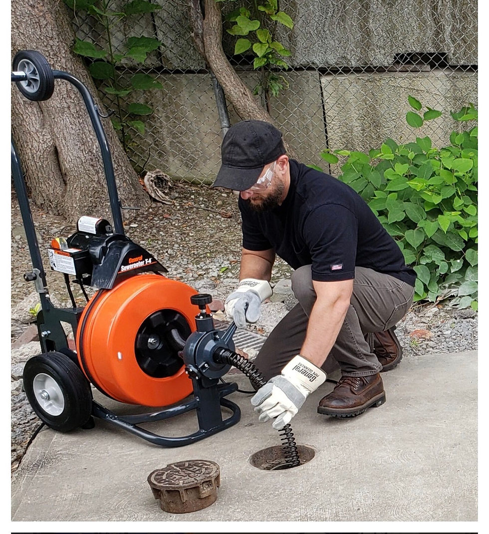 Plumbing technician performing drain cleaning