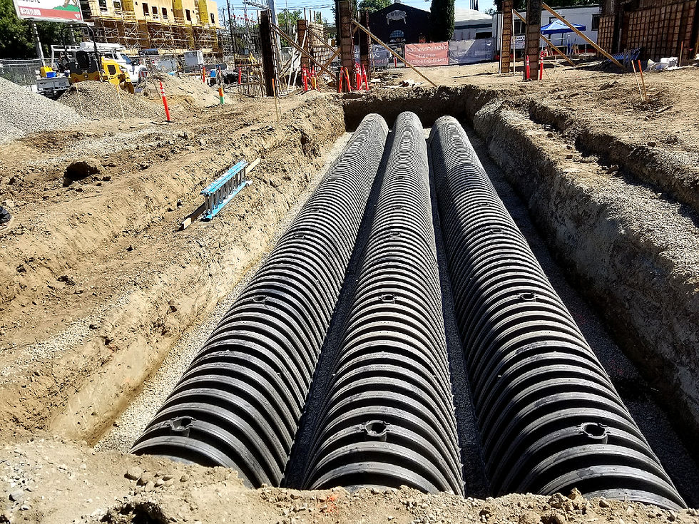 Three sewer pipes in a trench for underground utility installation