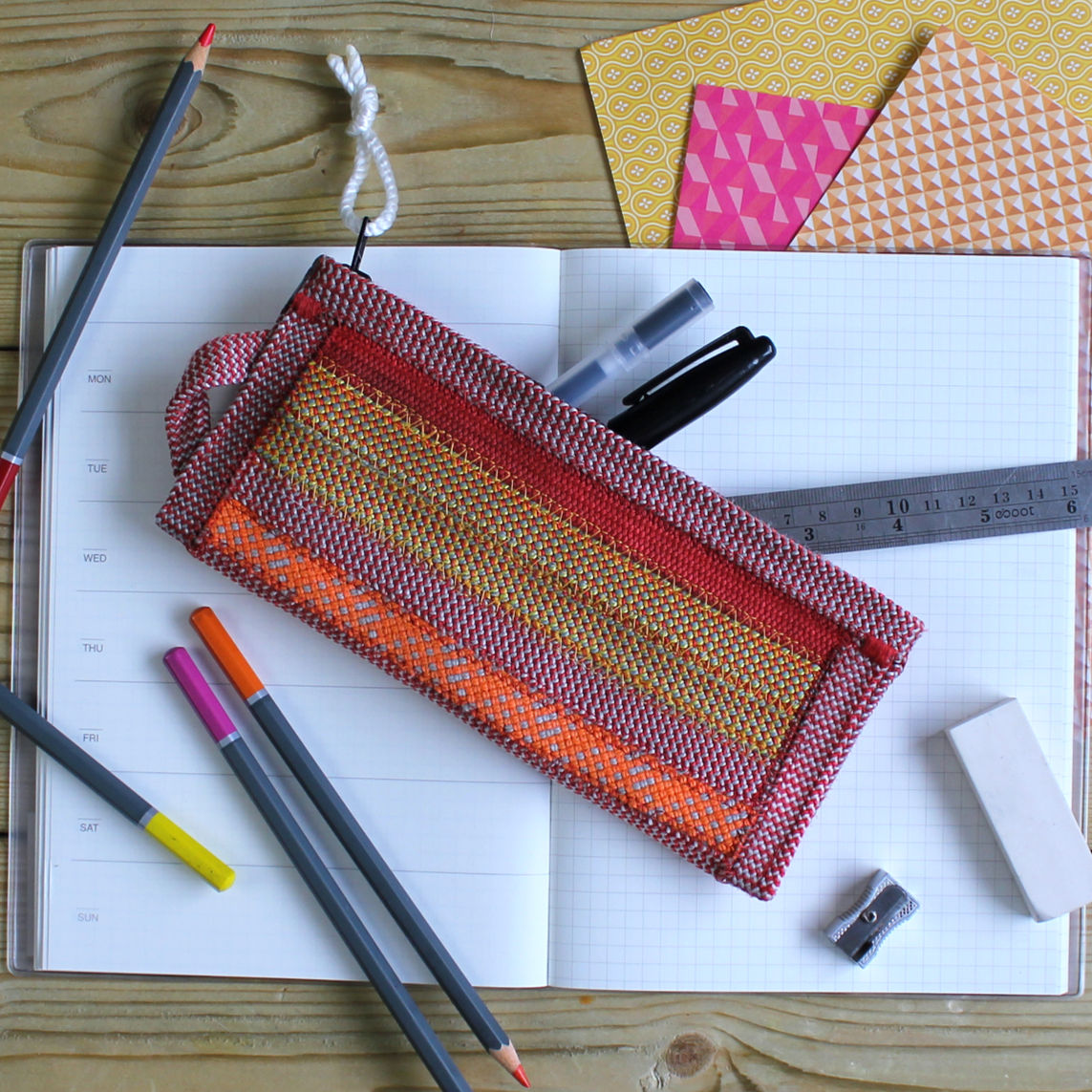 a climbing rope pencil case (zip pouch) is laid on a table with the contents laid out alongside